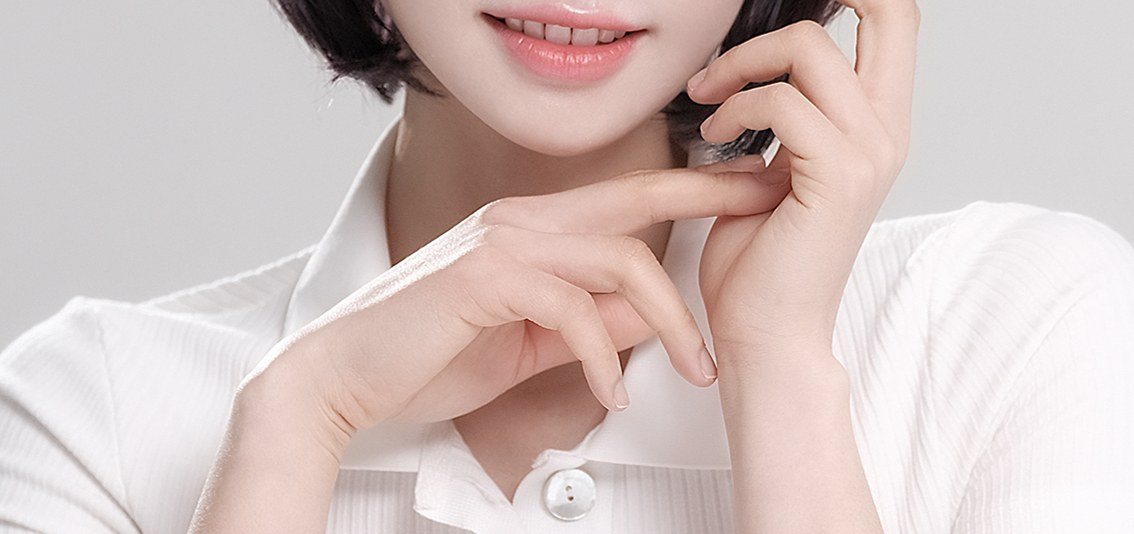 턱에 손을 괸 여성의 상반신 일부