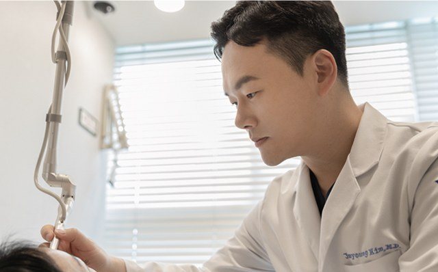 의사가 환자에게 레이저 장비로 시술하는 모습