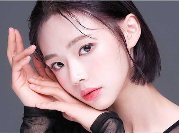 손을 턱에 괸 단발머리 여성의 얼굴 클로즈업 사진