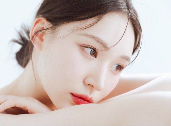 팔에 턱을 괴고 그윽하게 바라보는 여성의 얼굴 클로즈업 사진